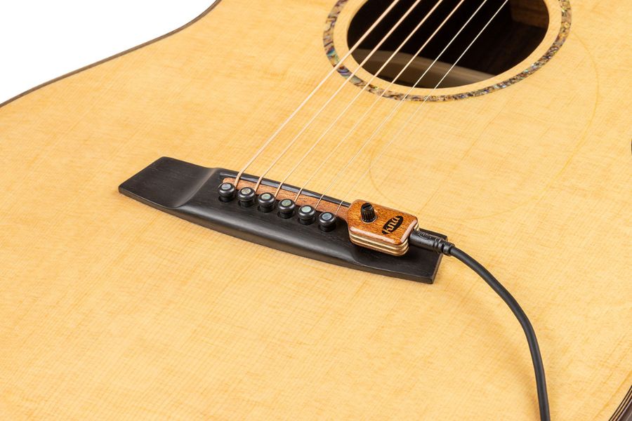 Piezo Pickups sit right under the strings at the bridge